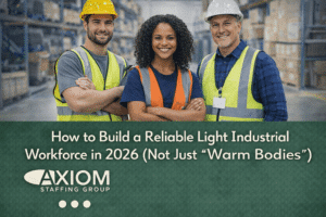 Three light industrial workers wearing safety vests and hard hats standing confidently in a warehouse, with headline text about building a reliable workforce in 2026.