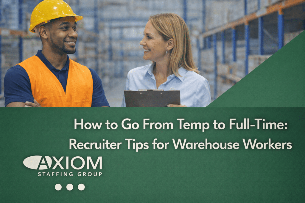 Warehouse worker wearing a safety vest and hard hat speaking with a recruiter holding a clipboard inside a distribution center, featured in a banner about transitioning from temporary to full-time warehouse employment at Axiom Staffing Group.